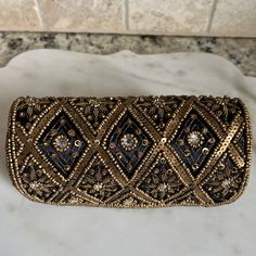 What A Beautiful Clutch. Had It For Years But Have Never Used It. Excellent Pre-Owned Condition. A Cute Cylinder Clutch With Intricate Gold Beaded Design All Over. Black Lining. Two Snaps For Closure. Black Beaded Pouch Clutch, Elegant Black Beaded Clutch, Black Beaded Rectangular Clutch, Elegant Rectangular Black Beaded Evening Bag, Traditional Embellished Black Clutch, Elegant Black Beaded Rectangular Evening Bag, Traditional Black Embellished Clutch, Embellished Black Rectangular Clutch, Black Embellished Rectangular Clutch