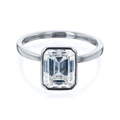 an emerald cut diamond ring on a white background