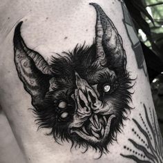 a black and white image of a demon with horns on his head, done by tattoo artist