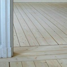 an empty room with white walls and wood floors