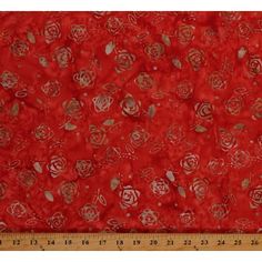 a red fabric with gold foil flowers on it and a ruler in the foreground