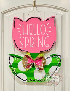 a hello spring door hanger with a bow on it