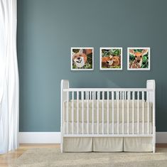 a baby's room with three pictures on the wall and a white crib