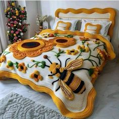 a bed covered in yellow and white crocheted bedspread with bees on it