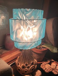 a blue glass lamp sitting on top of a wooden table