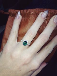 a close up of a person's hand with a ring on their finger and a bag