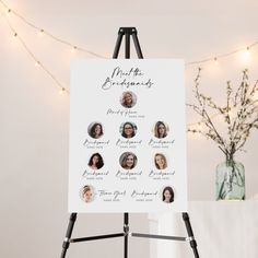 a white sign sitting on top of a easel next to a vase filled with flowers