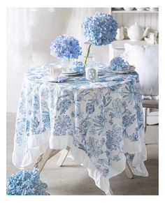 a table with blue flowers and plates on it