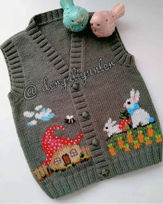 a gray sweater vest with an embroidered bunny and rabbit on the front, next to a small blue bird