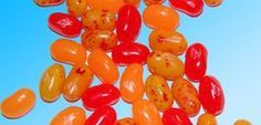 orange and red jelly beans against a blue background