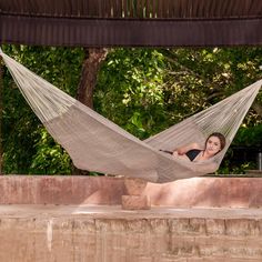 a woman is laying in a hammock