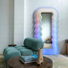 a living room with a couch, mirror and table in front of white brick wall