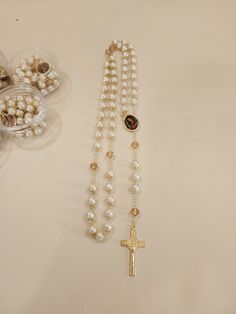 A Beautiful Rosary that makes the perfect gratitude gift to your guests in your special event or as a gift made by the godparents. Usually bought with a bible or by itself, this rosary is ideal to pray and keep as a memory from your special celebration.   12 pieces  Made out of metal and pearls (20 in. long approx)   *PLEASE NOTE THAT SLIGHT COLOR DIFFERENCE SHOULD BE ACCEPTABLE DUE TO LIGHT ENVIRONMENT AND MONITOR SCREEN* Elegant Pearl Rosary With Cross, Elegant Pearl Rosary For First Communion, Spiritual Pearl Rosary As Gift, Pearl Rosary With 8mm Beads As Gift, Pearl Rosary With Round Beads As Gift, Elegant Cross Rosary For First Communion, Pearl White Rosary For First Communion, Spiritual Pearl Rosary With 8mm Beads, Elegant Beaded Rosary For First Communion