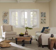 a living room filled with furniture and windows covered in white shuttered shades on the windows