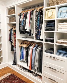 an organized closet with white shelving and drawers