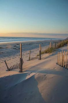 the beach is covered in sand and fence posts