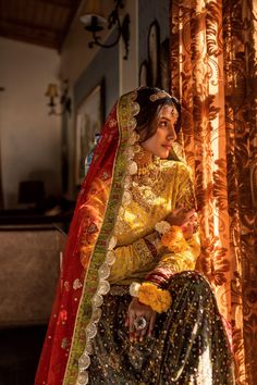 Barang-e-Chaman—a blossoming garden, resplendently captures all the features that make a mehndi the most distinguishably festive mark of a Pakistani wedding. The marigold-colored chiffon kurti is hand-embroidered with sequins and beads, with dabka, kora, and nakshi embroidery on the neckline and sleeves. Paired with a net dupatta with motifs all over in badla embroidery, and finally a raw silk lehenga colored using discharge printing and embroidered using antique-style beads, sequins, dabka, and Traditional Wedding Wear With Dabka On Jamawar, Naqshi Anarkali Set For Traditional Ceremonies And Festivals, Anarkali Traditional Wear With Intricate Design For Wedding, Multicolor Naqshi Anarkali Traditional Wear, Wedding Festive Jamawar Lehenga, Traditional Naqshi Lehenga For Festive Occasions, Traditional Naqshi Lehenga For Eid, Traditional Naqshi Choli For Eid, Traditional Lehenga With Naqshi For Eid