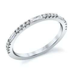 a white gold wedding band with baguettes and diamonds on the side, set in 18k white gold