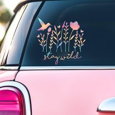 a pink car with the words stay wild on it's side window sticker