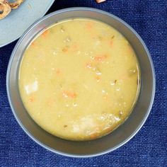 a bowl of soup next to a plate with pretzels on it and some crackers