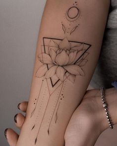 a woman's arm with a lotus tattoo on it