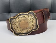 "LENGTH - 1-1/2\" Wide (38 millimeters wide) Elevate your men's western fashion with our exceptional Handmade Genuine Leather Western Belt. Crafted by our experts, this Cowboy Style belt is more than a simple accessory designed for the cowboy at heart. It's a rugged, one-of-a-kind statement piece needed in your wardrobe. BUCKLE - Handmade western style cowboy buckle made. Add your own personalization to customize your belt! SIZE - For the best fit, pick your belt at 2\" longer than your waist size. (For example, if you wear a size 34 pants, you should order a size 36 belt) 100% MONEY BACK GUARANTEE - Make a statement with our Traditional Cowboy Belt--shop with full comfort and security of our Money Back Guarantee system now and experience the perfect fusion of Genuine Leather, Cowboy Style Classic Hand Tooled Belt Buckles For Western-themed Events, Classic Brown Belt Buckles For Western-themed Events, Western Belt Buckles For Rodeo, Engraved Brown Belt Buckles For Western-themed Events, Western Hand Tooled Belt Buckles As Gift, Vintage Engraved Brown Belt Buckles, Vintage Brown Engraved Belt Buckles, Cowboy Buckle, Leather Belt Buckle