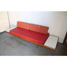 a red couch sitting next to a white dresser