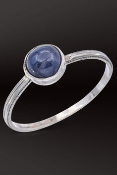 Elevate your style with this elegant antique 18K white gold ring boasting a mesmerizing 1.56 Ct sapphire round cabochon. A timeless piece for sophisticated allure. #SapphireJewelry #AntiqueGold #VintageStyle Classic Cabochon Sapphire Ring For Formal Occasions, Classic Formal Cabochon Sapphire Ring, Classic Formal Sapphire Cabochon Ring, Classic Domed Sapphire Ring With Polished Finish, Fine Jewelry White Gold Cabochon Sapphire Ring, Classic Sapphire Cabochon Rings, Formal Domed Cabochon Sapphire Ring, Classic Oval Cabochon Sapphire Ring With Bezel Setting, Classic Sapphire Ring With Oval Cabochon Bezel Setting