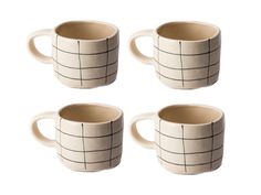 four coffee mugs sitting next to each other on a white surface with black lines