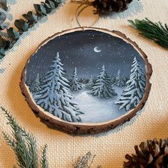 a wood slice with pine trees painted on it