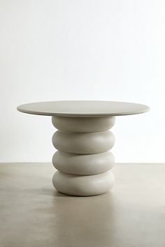 a white table sitting on top of a cement floor