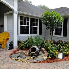 a house with landscaping in front of it and a yellow bench next to the building