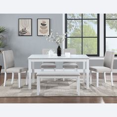 a dining room table with four chairs and a bench