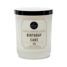 a birthday cake candle sitting on top of a white tablecloth next to a black lid