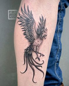 a black and white bird tattoo on the arm