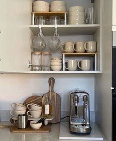 a kitchen shelf filled with dishes and cups