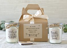 two mason jars are sitting on a table next to a box with a card inside