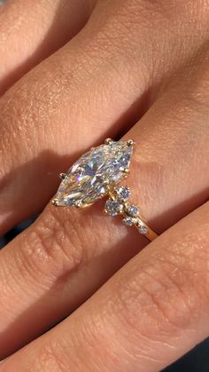 a woman's engagement ring with a pear shaped diamond in the center and side stones