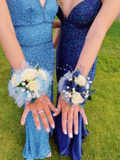 two bridesmaids in blue dresses holding bouquets of flowers and gloves on their hands