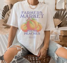 You've now found this peach aesthetic vintage T-shirt! It's made of 100% ring-spun cotton and therefore comfortable & soft and would be a perfect gift for a loved one, or for anyone who simply just loves fruits or anything that has to do with organic farming. This cute shirt is available in multiple colours and sizes. - MADE TO ORDER ITEM - - SHIRT DETAILS - * 100% ring-spun cotton * Sport Grey is 90% ring-spun cotton, 10% polyester * 4.5 oz/yd² (153 g/m²) * Shoulder-to-shoulder taping * Quarter-turned to avoid crease down the center * Blank product sourced from Bangladesh, Honduras, Haiti, Mexico, or Nicaragua Your T-shirt will be printed using the DTG technique. Please note that due to differences between display types the colours of the print on your T-shirt may be slightly different to Peach Aesthetic Vintage, Farmers Market Tshirt, Farmers Market Shirt, Recruitment Shirts, Fruit Shirt, Mom Graphic Tees, Off Shoulder T Shirt, Peach Aesthetic, Trendy Mom