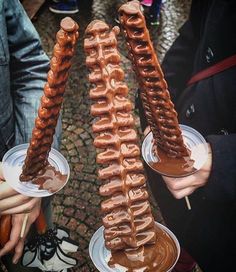 two people holding plates with donuts on them and dipping sauces in the middle