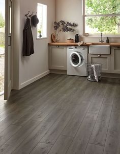 a washer and dryer in a kitchen with wood flooring on the walls