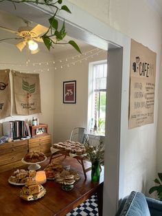 a wooden table topped with plates of food next to a window covered in burlap