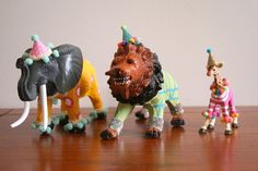 three figurines are standing on a wooden table