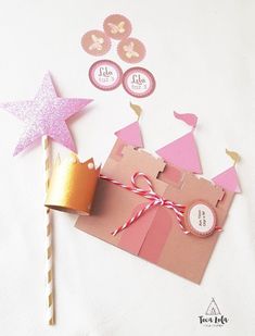 pink and gold princess party decorations on top of a table with cupcakes, wands and paper stars