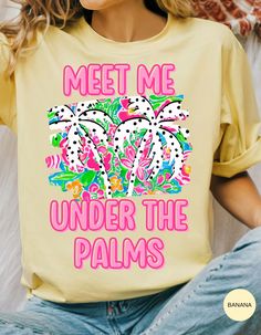 Escape to your tropical haven with our **Palms Paradise Rendezvous Tee**! This breezy, soft cotton shirt features the whimsical phrase "Meet Me Under the Palms," inviting you to daydream about sun-soaked beaches and swaying palm trees. Perfect for summer adventures, beach outings, or just adding a touch of paradise to your everyday style. Embrace the laid-back vibes and make every day a getaway with this must-have tee! Printed Yellow T-shirt For Vacation, Yellow Printed T-shirt For Vacation, Tropical Print T-shirt For Vacation, Tropical Palm Tree Print Vacation Top, Tropical Palm Tree Print Tops For Vacation, Tropical Palm Tree Print Tops For Beach Party, Tropical Style Shirts With Screen Print For Beach Season, Tropical Tops With Palm Tree Print For Beach Party, Yellow Vacation T-shirt For Spring