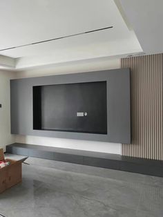 an empty room with a large screen on the wall