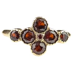 An interesting and pretty vintage Garnet cluster ring. It has a rich yellow gold mount with an array of bezel set rich red garnets with a tiny prong set stone to the very centre if the arrangement. There are seven round cut garnets in total and the ring has an older look to it with the bezel settings. The ring has smooth yellow gold shoulders and a smooth slender band. Marks and era: Fully hallmarked for 9ct gold, London Assay office, 1986. Condition: Good used condition overall, some age commensurate surface wear and signs of use, stones with some scratches and small nibbles. UK/AU ring size J½ US ring size 5 MM ring size 49.32 Total weight 1.54 grams Approx 8mm length ring Face and 1.7mm band width. The ring does not come boxed it is shown in the images boxed for display purposes only. G Vintage Cluster Ring, Brilliant Earth Rings, Precious Jewels, Garnet Jewelry, Antique Engagement Rings, Brilliant Earth, Online Wedding, I Love Jewelry, Planning Ideas