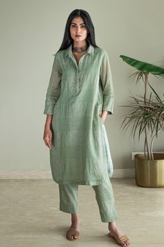 Green shirt kurta with zari jamdani checkered in silver zari woven motifs. Paired with pant.
Components: 2
Pattern: Woven
Type Of Work: Zari, checkered
Neckline: Collar
Sleeve Type: Three quarter
Fabric: Kurta: Zari Jamdani Checks Muslin, Lining: Shantoon
Color: Green
Other Details: 
Side pockets
Embroidered placket
Front concealed button placket
Rounded hem
Attached lining
Note: Necklace worn by the model is not for sale
Disclaimer: The fabric, color and texture of the final garment might have Shorshe Clothing, Collar Kurti Design, Collar Kurti, A Line Kurti, Stylish Kurtis Design, Kurta Patterns, Green Checkered, Simple Kurta Designs, Kurti Patterns