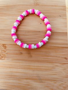 A pink and white clay bead bracelet with white seed beads Pink Heishi Beads Jewelry With Spacer Beads, Pink Heishi Beads Bracelet, Pink Heishi Beads Bracelets, Pink Heishi Beads Bracelet With Colorful Beads, Pink Heishi Beaded Bracelets With Colorful Beads, Pink Heishi Beads Colorful Beaded Bracelets, Pink Heishi Beads Bracelets With Colorful Beads, Pink Heishi Beads Bracelet With Letter Beads, Pink Beaded Bracelet With Heart And Heishi Beads